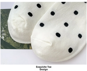Detailed close-up of seamless toe stitching on white socks with black polka dots