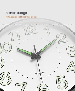 Detail of luminous metal pointers and quartz movement on a minimalist 14-inch wall clock