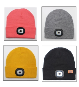 Detail of knitted LED beanies in pink, grey, yellow and black with light module