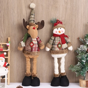 Close-up of plush Christmas reindeer and snowman figurines against a warm wooden wall