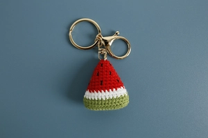 Detailed close-up of handmade crochet watermelon slice keychain with golden lobster clasp