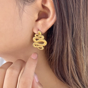 Orecchini a forma di serpente placcati oro 18K mostrati sulla modella per un look punk