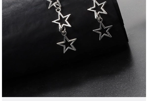 Macro shot of silver hollow star earrings with polished finish and linked star structure