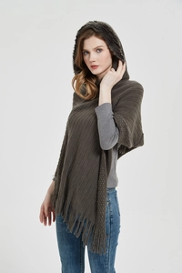 Detailed knit texture and faux fur collar of a dark coffee hooded tassel poncho