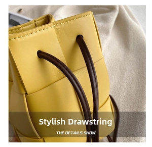 Detail showing the wide woven leather texture and brown drawstring of yellow bucket bag
