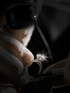 Close-up of a 4-prong set round brilliant cut diamond on a silver earring stud detail