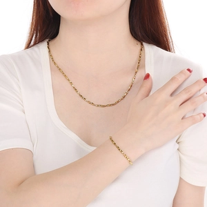 Minimalist gold Chopin chain necklace and bracelet set displayed on a fashion model