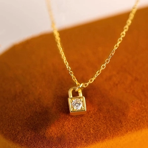 Chic gold pendant necklace featuring a delicate lock design with a central sparkling gem