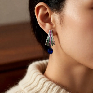 Detail of vintage silver earring with colorful zircon stones worn by a model