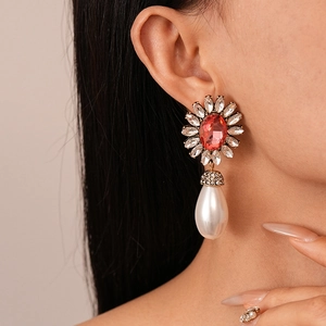 Detail of vintage baroque floral earring with red gemstone and drop pearl pendant