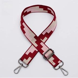 Close-up of adjustable burgundy woven shoulder strap with pink patterns and gunmetal hardware