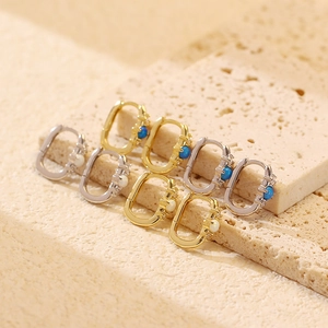 Dettaglio macro di orecchini a cerchio ovali in oro e argento con opale e diamanti