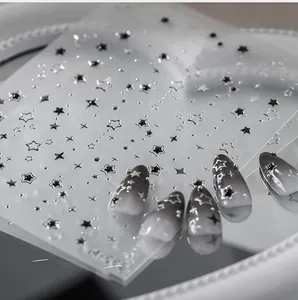 Vue macro d'autocollants pour ongles étoiles métalliques avec texture relief argentée