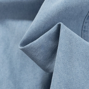 Gros plan sur le denim bleu montrant la texture détaillée du sergé et la qualité du tissu