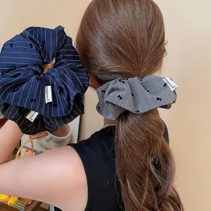 Chouchou en tissu rayé avec broderie nœud et étiquette Happiness pour queue de cheval haute