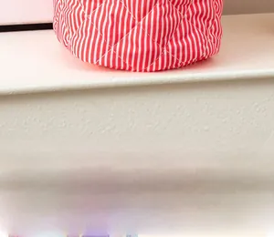 Detailed close-up of the red and white striped quilted base on the fabric storage basket