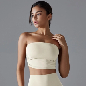 Detalle del top deportivo bandeau beige sin costuras con textura plisada lateral