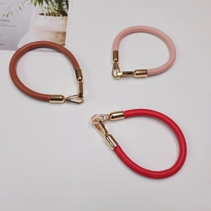 Three-color leather bag wrist straps in brown, pink, and red with gold metal hooks
