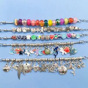 Detailed flat lay of colorful enamel and glass charms for DIY modular bracelets