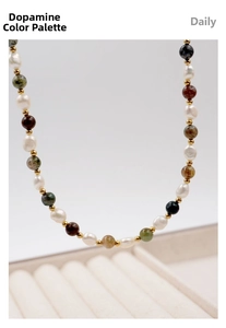 Detail of colorful stone and freshwater pearl necklace with gold spacer beads