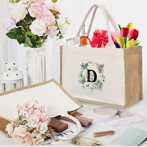 Detail of linen canvas tote bag with letter D print and floral butterfly wreath design