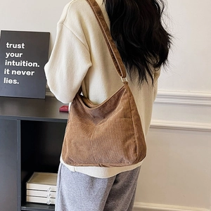 Brown corduroy shoulder bag with large capacity shown on model in a minimalist setting