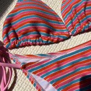 Dettaglio bikini in spugna a righe con finitura vellutata e lacci laterali rosa