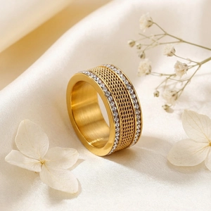 Detail of gold braided mesh ring with double rows of sparkling zircon on beige silk