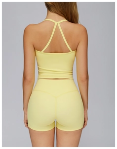Detail of light yellow yoga set showing the cross-strap back design and brushed fabric texture