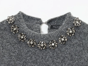 Dettaglio maglieria in mohair grigio con decorazioni floreali in strass sul colletto