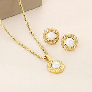 Detail of gold twist chain necklace and pearl stud earrings set with crystal pavé
