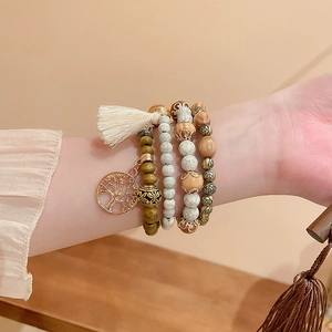 Close-up of bohemian layered sandalwood beads with tree of life charm and tassel