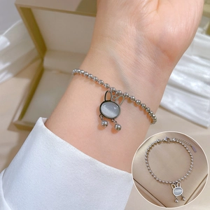 Silver beaded bracelet with cat eye stone rabbit pendant worn on a female wrist
