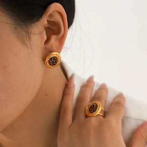 Set of 18k gold plated oval leopard print earrings and ring on a model with natural lighting