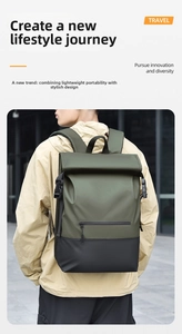 Detail view of the olive green and black roll-top backpack shown on a model outdoors