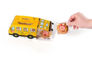 Detail showing open yellow school bus gift box with individually wrapped bear cookies inside