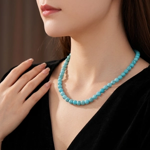 Elegant turquoise beaded necklace with sky blue round stones worn by a female model