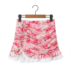 Floral mini skirt with ruffled details, lace hem, and pearl buttons on a wooden hanger