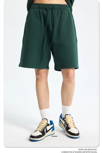 Detail of dark green cotton shorts showing the drawstring elastic waistband texture