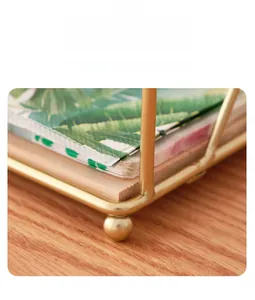 Macro detail of the round gold metal base on a minimalist square napkin holder rack