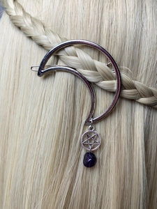 Detail of silver crescent moon hair clip with purple crystal on blonde braided hair
