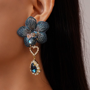 Détail de la boucle d'oreille fleur brodée bleu foncé avec cœur strass et gemme goutte