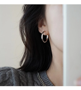 Close-up of minimalist S925 sterling silver hoop earring worn on a model's ear