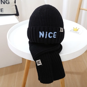 Detail of NICE letter embroidery on thick black knitted hat and scarf set for winter