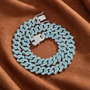 Detail of 15mm silver cuban chain with blue rhinestones on brown textile background