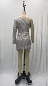 Détail d'une robe de soirée à paillettes argentées avec une épaule et franges scintillantes