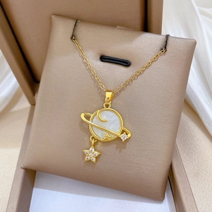 Detailed macro view of gold-plated star and moon shell pendant with sparkling zircon accents