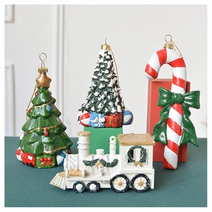 Detailed view of Christmas ornaments set including snow-dusted trees and vintage train