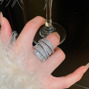 Macro shot of silver-colored layered wide ring with cubic zirconia on model hand