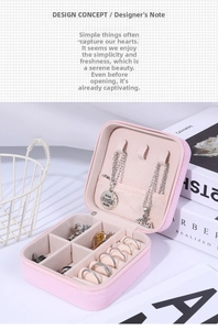 Detail of pink faux leather travel jewelry box showing multi-grid interior and ring slots